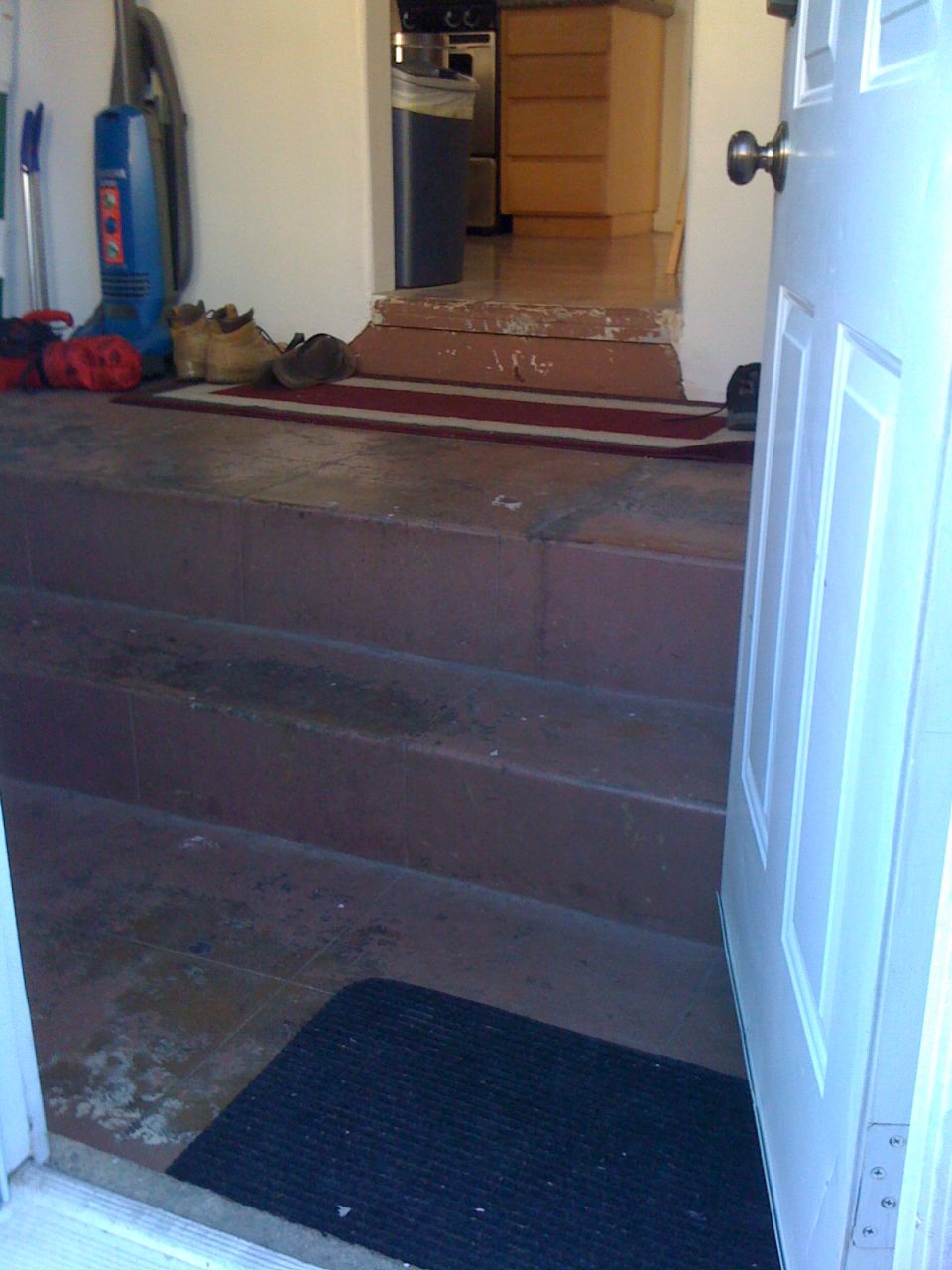 Entryway with stairs, a vacuum cleaner, and shoes by the door
