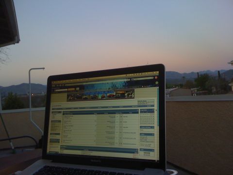 1968 Ford Mustang - Laptop displays car website with thumbnails and data table at sunset.