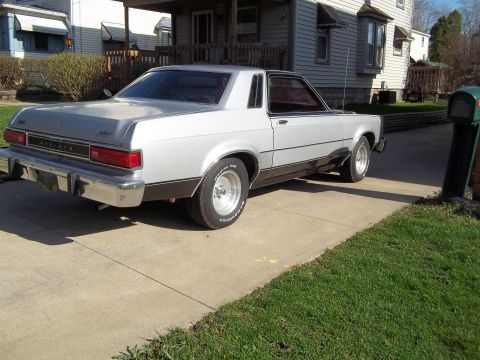 1970 Ford Ranchero - Rear view of a silver coupe with a black lower body stripe and chrome bumper.