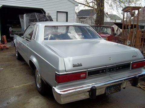 1970 Ford Ranchero - A silver sedan with a Monarch badge is parked in a garage, with another vehicle visible inside.