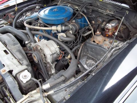 1970 Ford Ranchero - A view of the engine bay, the air cleaner and alternator. Some text is visible on a hose.