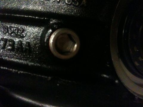 2010 Dodge Challenger - Close-up view of a hex bolt on a black metal component, showing some casting numbers.