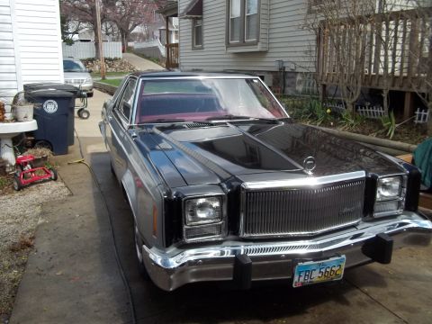 1970 Ford Ranchero - A black Ford Granada is parked in a driveway next to a house and trash cans.
