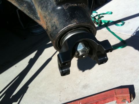 2009 Suzuki Samurai - A close-up view of a vehicle's rear axle part, showing a U-joint yoke and a hex nut.