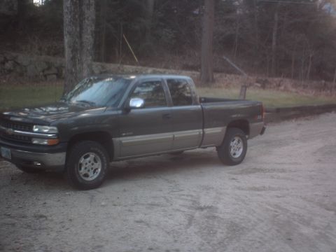 2002 Chevrolet C/K Pickup - A 2002 Chevrolet C/K Pickup truck is parked on a gravel surface with trees in the background.