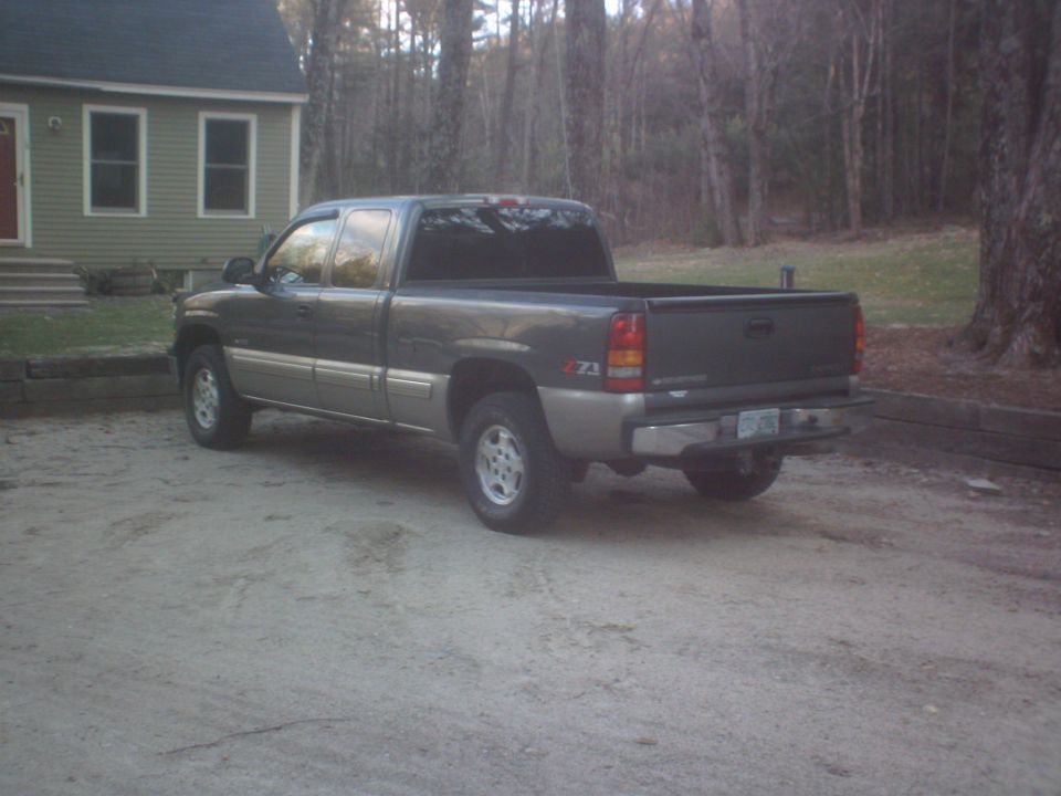 Dark gray and tan 2002 Chevrolet C/K Pickup truck, rear 3/4 view