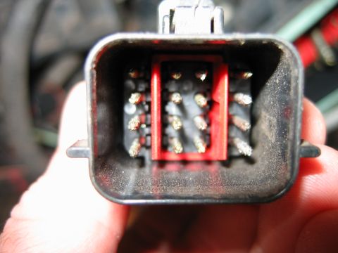 1992 Ford Bronco - Close-up of a vehicle's wiring harness connector, showing pins and a red insert. The Supermotors.net logo is visible at the bottom.