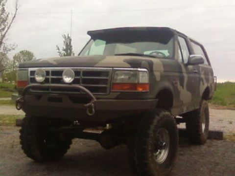 1995 Ford Bronco - This lifted Ford Bronco features a camouflage paint job and an aggressive aftermarket bumper.