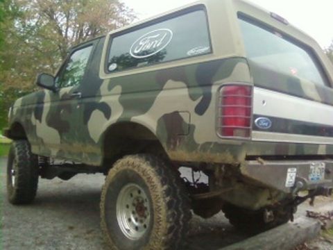 1995 Ford Bronco - This 1995 Ford Bronco features a camouflage paint scheme and a Ford logo on the rear window.