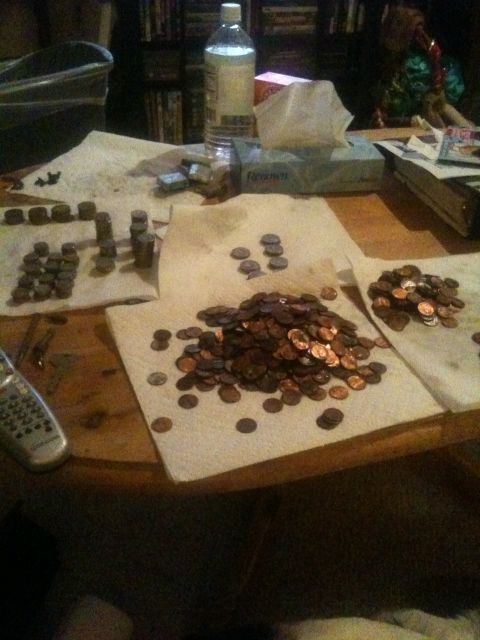 1994 Ford Bronco - Coins are laid out on paper towels on a table, with a bottle of water and tissues in the background.