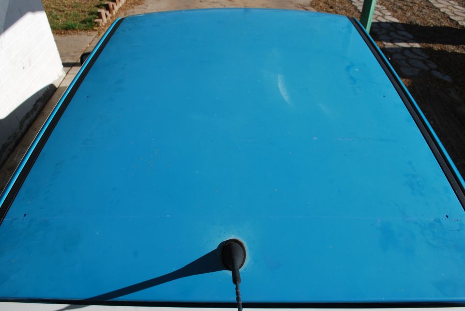 blue car roof with black trim and antenna base