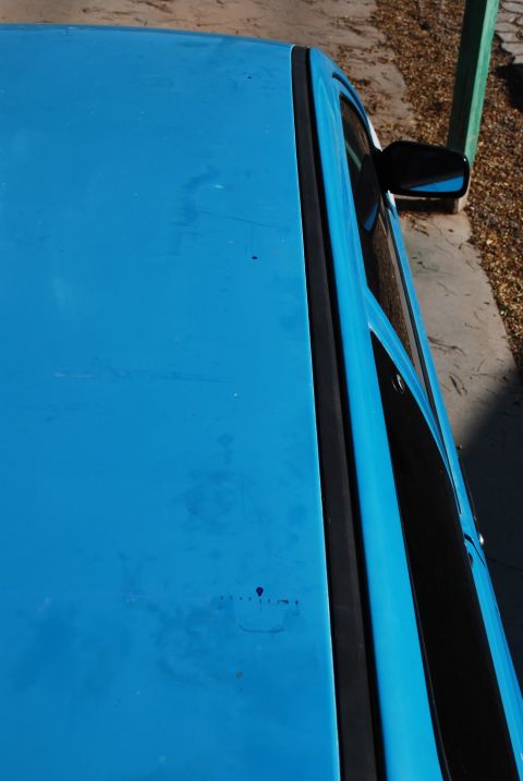 1991 Ford Festiva - Close-up view of the roof and side window of a blue car.