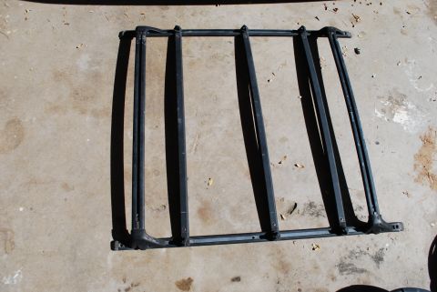 1991 Ford Festiva - Roof rack assembly shown disassembled on a concrete surface.