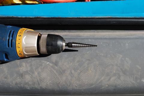 1991 Ford Festiva - Power drill and step bit are shown close up, with yellow settings visible on the drill body.