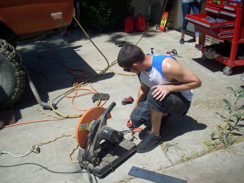1992 Ford Ranger - A person works on a vehicle in a driveway with tools and equipment nearby.