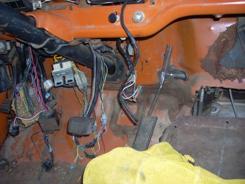 1992 Ford Ranger - Exposed wiring and pedals dominate the interior view of this vehicle, with an orange dashboard and a yellow cover present.