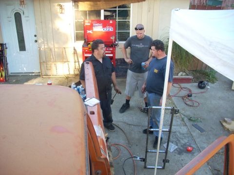 1992 Ford Ranger - Three men are gathered around the front of an orange vehicle, appearing to be in the middle of some work.