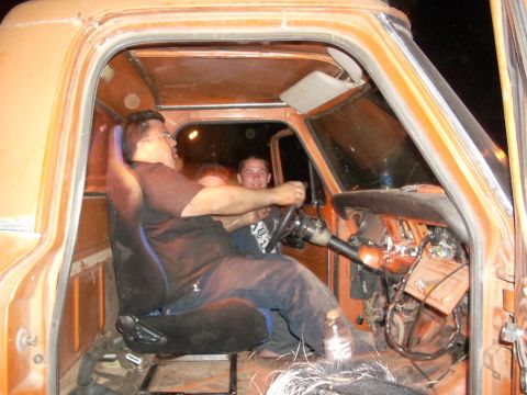 1992 Ford Ranger - Two men inside the cab of an orange truck, one appears to be driving.