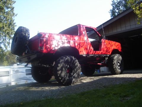 1989 Ford Bronco - This modified SUV features oversized tires and a spare tire carrier, suggesting off-road capabilities.