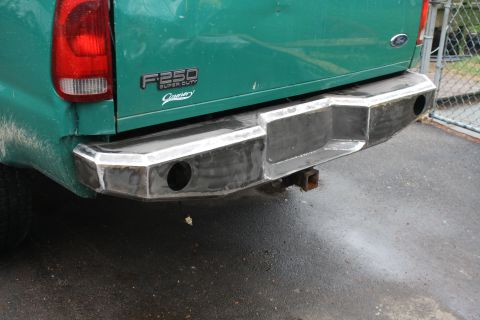 2003 Ford F-250 - Custom rear bumper on a green 2003 Ford F-250 Super Duty truck, integrated tow hitch.