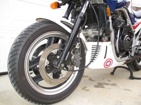 1984 Honda Interceptor - Close-up of a motorcycle's front wheel and suspension system, a custom Captain America decal on the fairing.