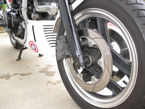 1984 Honda Interceptor - Close-up of a motorcycle's front wheel and braking system, a Captain America emblem on the fairing.