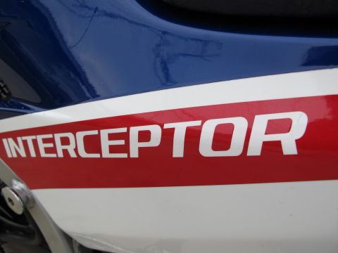1984 Honda Interceptor - Close-up of a motorcycle's side panel displaying the 'INTERCEPTOR' name in white lettering on a red stripe.