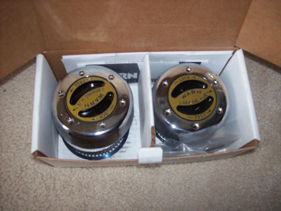 Two chrome Warn locking hubs in a cardboard box, labeled 'WARN LOCKING HUB' and 'FREE'/'LOCK'