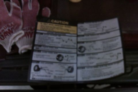 1994 Chevrolet Blazer - A caution sticker with instructions and diagrams is visible next to a pair of pink work gloves.