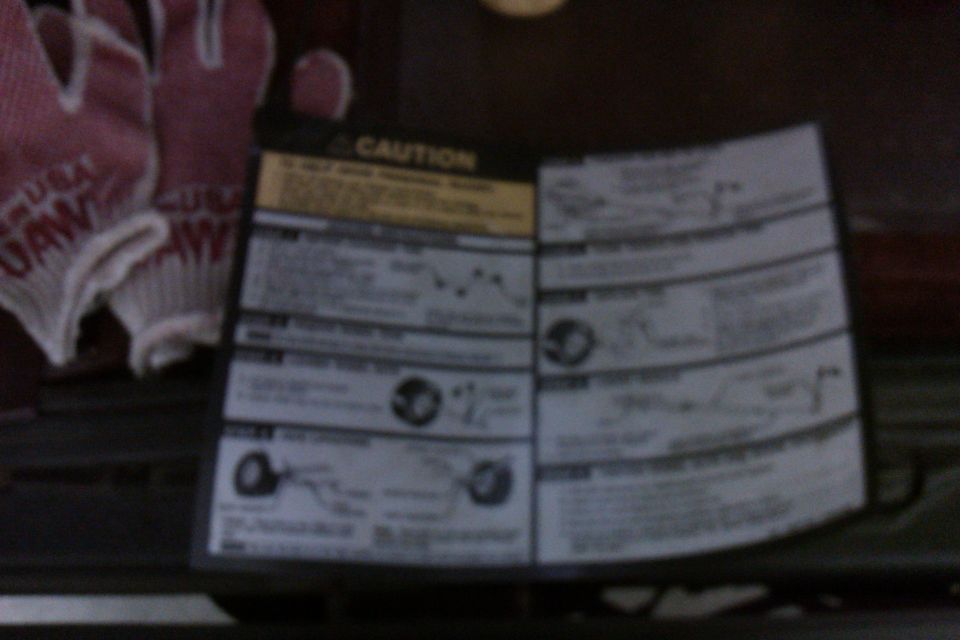 caution sticker with diagrams and text, next to pink work gloves