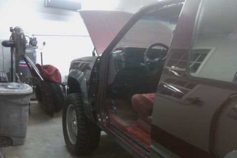 1994 Chevrolet Blazer - Interior view of a maroon SUV with the driver's door open, revealing the dashboard and seats.