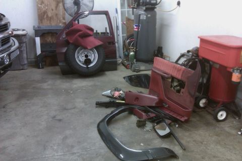 1994 Chevrolet Blazer - Vehicle body and parts are disassembled and stored in a garage, with a spare tire visible on the side of the main body section.
