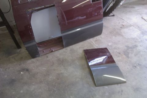 1994 Chevrolet Blazer - A car door and a piece of its trim are disassembled and lying on the floor.