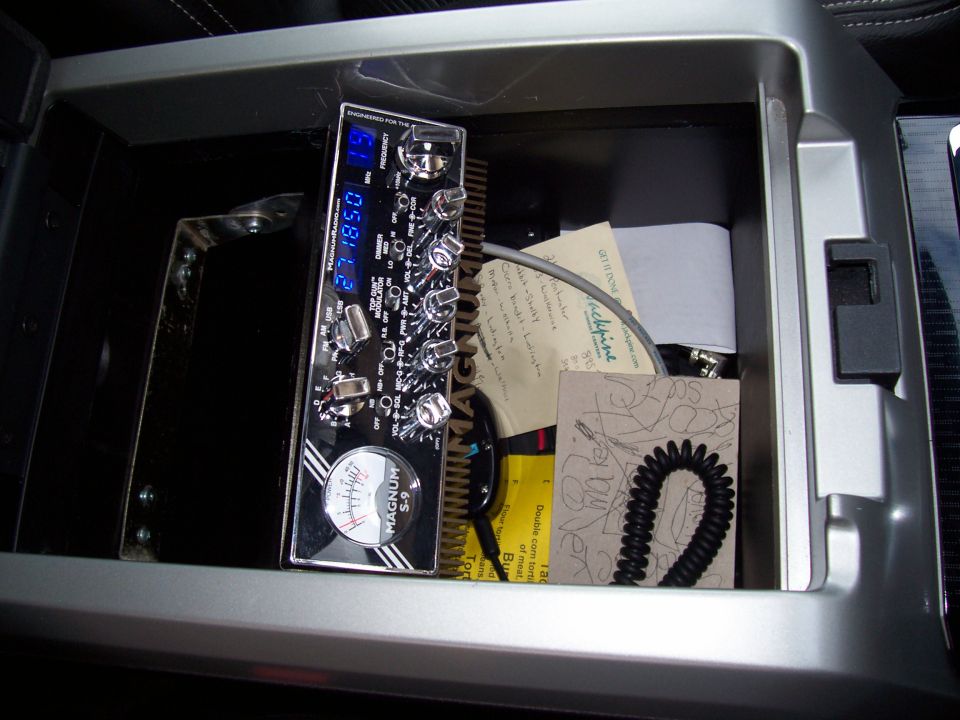 CB radio with digital display and knobs in a vehicle's center console