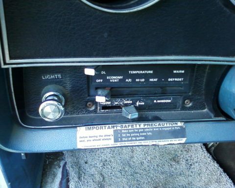 1976 Ford Torino - Interior view of dashboard climate controls and a safety warning sticker.