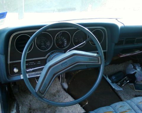 1976 Ford Torino - The interior of a 1976 Ford Torino shows its blue dashboard, steering wheel, and gauges.