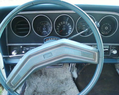 1976 Ford Torino - The interior of a 1976 Ford Torino shows its dashboard with a blue steering wheel and instrument cluster.