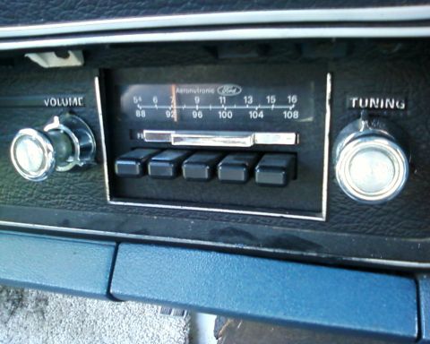 1976 Ford Torino - Close-up of a car's interior radio controls, including volume and tuning knobs.