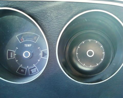 1976 Ford Torino - Close-up of a vehicle's dashboard gauges, including temperature and warning lights.