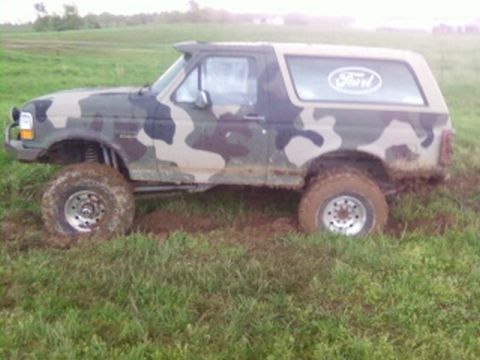 1995 Ford Bronco - This 1995 Ford Bronco is covered in camouflage and appears to be stuck in the mud.