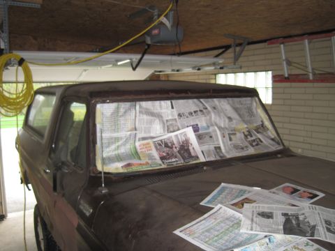 1979 Ford Bronco - This vehicle is covered in newspapers, likely for protection during a repair or painting project.