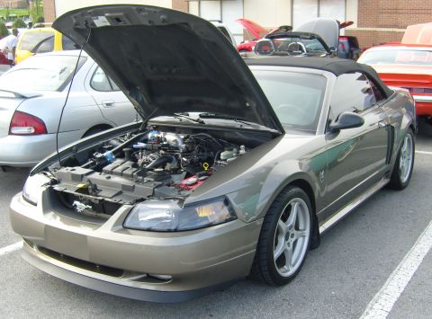 2007 Ford Mustang - A tan convertible Mustang is parked with its hood open, revealing the engine compartment.