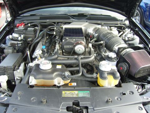 2007 Ford Mustang - The engine bay of a 2007 Ford Mustang features a K-Bell supercharger and a custom air intake system.