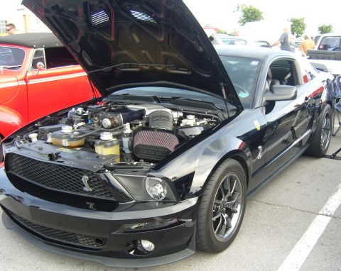 2007 Ford Mustang - Black 2007 Ford Mustang with hood open, parked next to a red classic car.