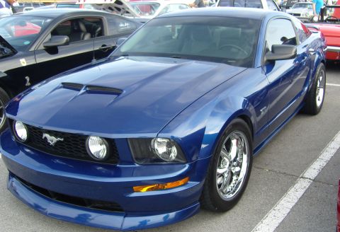 2007 Ford Mustang - A blue Ford Mustang is parked in a lot next to another Mustang.