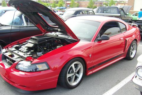 2007 Ford Mustang - Red 2007 Ford Mustang coupe with hood open, parked in an outdoor lot with other vehicles.
