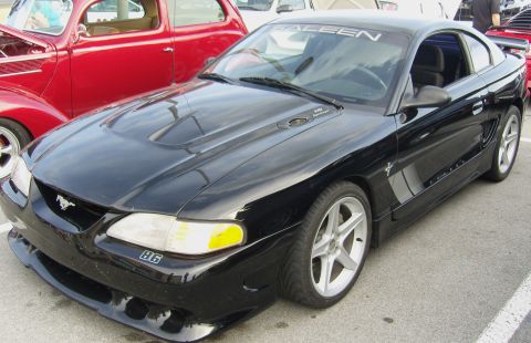 2007 Ford Mustang - A black Saleen Mustang is parked next to a red classic car.