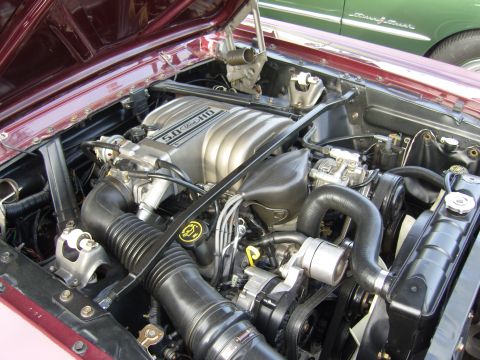 2007 Ford Mustang - The engine bay of a car, a 5.0 HO engine, with another vehicle partially visible in the background.