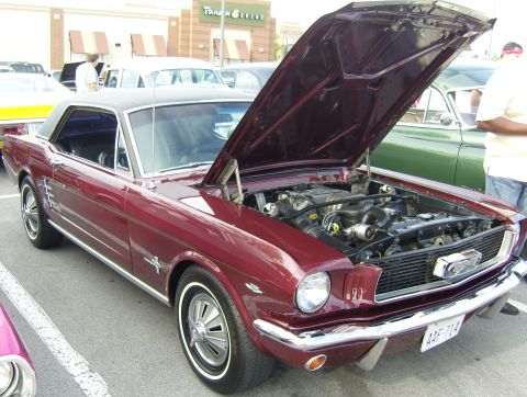 2007 Ford Mustang - Maroon coupe with hood open, parked outdoors with other vehicles and buildings in the background.