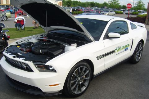 2007 Ford Mustang - A white 2010 Ford Mustang GT/CS is displayed with its hood open, revealing the engine bay and a side decal.